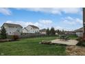 Large backyard with green grass, fence, and patio with table and chairs at 8536 Blue Marlin Dr, Indianapolis, IN 46239