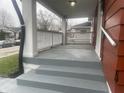 Covered front porch with painted floor and steps. Includes updated railing and views of the friendly neighborhood at 937 N Bosart Ave, Indianapolis, IN 46201