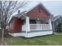 Craftsman home showcasing freshly updated landscaping, featuring a cozy porch and an American flag at 937 N Bosart Ave, Indianapolis, IN 46201