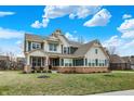 Beautiful home with dark shutters, a brick-lined foundation, and lush green grass at 10237 Sand Run Ln, Fortville, IN 46040