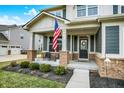 Charming front porch with brick columns, seating, and a welcoming entrance at 10237 Sand Run Ln, Fortville, IN 46040