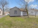 Charming home featuring gray siding, brown roof, and leafless tree in the front yard at 1241 Brandt Dr, Indianapolis, IN 46241