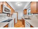 Functional kitchen with classic wooden cabinets, white appliances, and ample countertop space at 1330 N Gibson Ave, Indianapolis, IN 46219