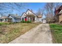 Attractive home with a vibrant red door, manicured shrubs, and a long driveway at 136 W 43Rd St, Indianapolis, IN 46208