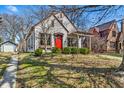 Quaint home featuring a bright red door, established greenery, and a detached garage at 136 W 43Rd St, Indianapolis, IN 46208