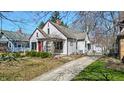 Neat home showcasing a bold red door, trimmed bushes, and a private driveway at 136 W 43Rd St, Indianapolis, IN 46208
