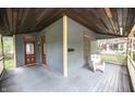 Detailed view of the covered front porch, showcasing a cozy chair, woodwork, and exterior door at 1542 Maple Ave, Noblesville, IN 46060