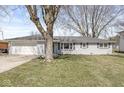 Charming single-story home with a well-maintained lawn and attached two car garage at 1710 Bittersweet Dr, Anderson, IN 46011