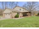 View of home and backyard, featuring large, covered patio and attached two-car garage at 2539 S Edgewood Cv, Martinsville, IN 46151