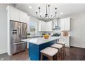 Modern kitchen features white cabinets, stainless steel appliances, and a blue island at 2748 Carrollton Ave, Indianapolis, IN 46205