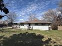 The house has white siding, a brown roof, and a small yard space with a partial fence and some trees at 3314 Argyle Ct, Indianapolis, IN 46226
