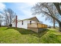 Exterior house featuring a chimney and wooden deck extending the side of the property with green grass at 3721 S 575 W, Trafalgar, IN 46181