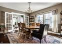 Light-filled dining room with a round table, chandelier, and adjacent sitting room with French doors at 3926 Rookwood Ave, Indianapolis, IN 46208
