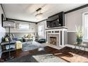 A cozy living room featuring hardwood floors, a fireplace, a crystal chandelier, and stylish decor at 3926 Rookwood Ave, Indianapolis, IN 46208