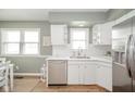 Bright kitchen featuring white cabinetry, stainless steel appliances, and a large window at 3929 Lee St, Anderson, IN 46011