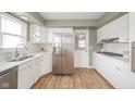 Modern kitchen featuring stainless steel appliances, white cabinets, and vinyl flooring at 3929 Lee St, Anderson, IN 46011