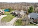 An aerial view of a brick home with pond, mature trees and backyard at 400 S Prairie Trce, Muncie, IN 47304