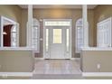 Bright foyer featuring tiled floors, decorative glass door, and half-wall columns at 400 S Prairie Trce, Muncie, IN 47304
