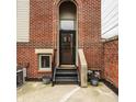 Rear entrance with black metal stairs, brick facade, and potted plants at 503 Lockerbie N Cir, Indianapolis, IN 46202