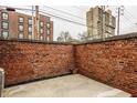 Enclosed brick patio featuring concrete and room for outdoor decor, with buildings in the background at 503 Lockerbie N Cir, Indianapolis, IN 46202