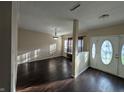 Elegant entryway with dark wood floors, decorative molding, and natural light from the front door windows at 5565 Noble Dr, Indianapolis, IN 46234