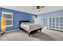 Spacious bedroom with neutral carpet, a ceiling fan, and bright windows for natural light at 714 Breakers Ln, Fortville, IN 46040