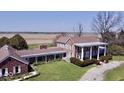 Sprawling brick home featuring a pillared porch, lush lawn, and open field views at 7180 N State Road 42, Eminence, IN 46125