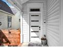 Close-up of a modern front door with a stained glass transom window and wood accent fence at 724 Lafayette Ave, Columbus, IN 47201