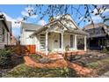 Inviting white house with a brick walkway, a cozy porch, and delightful curb appeal at 724 Lafayette Ave, Columbus, IN 47201