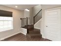 Welcoming entryway featuring dark vinyl flooring, iron railing staircase, and a bright front window at 7247 Barker St, Carmel, IN 46033