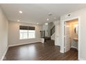 Bright living room with vinyl floors, large windows, and an adjacent half bathroom, providing a comfortable space at 7247 Barker St, Carmel, IN 46033