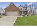 Inviting two-story home with a brick and siding exterior, attached garage, and well-kept lawn at 894 Woodgate Ln, Greenwood, IN 46143
