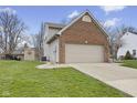 Side view of the home with a two-car attached garage and well-maintained yard with an outbuilding at 894 Woodgate Ln, Greenwood, IN 46143