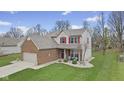 Attractive two-story home boasts a well-maintained lawn, brick accents, and a welcoming front porch at 894 Woodgate Ln, Greenwood, IN 46143