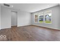 Bright, airy living room with luxury vinyl plank flooring and large windows overlooking the yard at 1023 Grassy Br Dr, Indianapolis, IN 46239