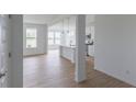 Bright open-concept space with a view of the kitchen, large windows, and hardwood floors at 1023 Grassy Br Dr, Indianapolis, IN 46239