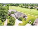 Aerial view of a brick house next to a golf course and other well-maintained lawns at 10844 Fairwoods Dr, Fishers, IN 46037