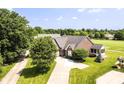 Aerial view of the brick home with well-maintained landscaping, a screened-in porch, and a long driveway at 10844 Fairwoods Dr, Fishers, IN 46037