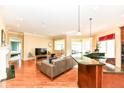 A spacious living room featuring hardwood floors, fireplace, and an open view to the kitchen at 10844 Fairwoods Dr, Fishers, IN 46037