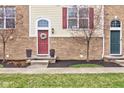 Attractive front entrances of townhomes with colorful doors, brick exteriors, and manicured landscaping at 12683 White Chapel Cir, Fishers, IN 46037