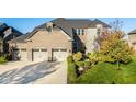 Stunning two-story home with a three-car garage and lush landscaping creates appealing curb appeal at 14910 Briarpatch Cir, Carmel, IN 46033