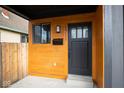 Inviting front entrance showcasing wood paneling, modern lighting, and a sleek black door at 1711 Ringgold Ave, Indianapolis, IN 46203