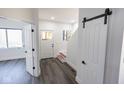 Hallway featuring stylish barn door, staircase, and access to adjacent rooms at 1711 Ringgold Ave, Indianapolis, IN 46203