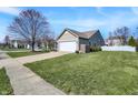 Well-maintained home exterior featuring a spacious lawn, concrete driveway, and attached two-car garage at 18875 Pilot Mills Dr, Noblesville, IN 46062