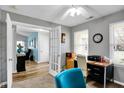 Bright office with neutral walls, carpet, and a view into a cozy sitting room, blending work and relaxation at 18875 Pilot Mills Dr, Noblesville, IN 46062