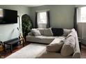 Bright living room features a large sectional sofa, hardwood floors, and natural light from windows at 212 Walnut St, Greenfield, IN 46140