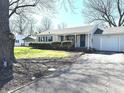 Inviting home featuring a quaint covered porch, attached single-car garage, and neatly trimmed front yard at 2843 Canterbury Ln, Indianapolis, IN 46220