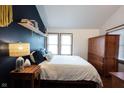 Comfortable bedroom with a blue accent wall, shelving, and abundant natural light at 2909 Huntsville Rd, Pendleton, IN 46064