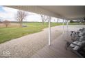 Inviting covered front porch with wooden deck and views of open fields and gravel drive at 2968 W Old Franklin Rd, Shelbyville, IN 46176