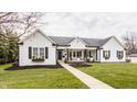 Charming home with white siding, black shutters, a manicured lawn, and inviting front porch at 311 2Nd Ne St, Carmel, IN 46032